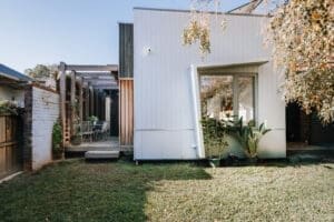 MARIAN HAWTHORN Contemporary backyard extension by Coys Constructions with vertical timber cladding, pergola walkway, and landscaped garden.
