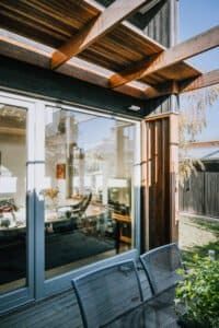 MARIAN HAWTHORN Modern timber pergola with sliding glass doors and alfresco dining, designed by Coys Constructions in Victoria.